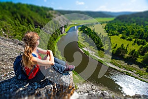 Woman hiker sits on the rock