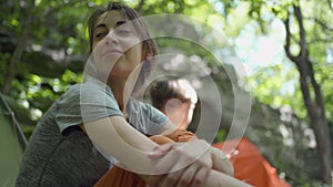 woman hiker sitting in camping in forest close to tent. outdoor activity, summertime vacation travel, hike and camping.