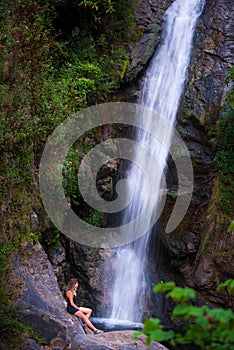 Woman hiker sitting near Mae Pan waterfall  in Doi Inthanon National Park near Chiang Mai
