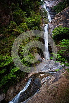 Woman hiker sitting near Mae Pan waterfall  in Doi Inthanon National Park near Chiang Mai