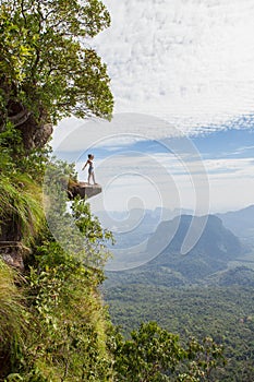 Woman hiker standing on a cliff