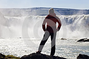 Woman Hiker Standing In Front Of a Huge Waterfall