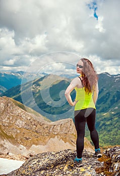 Woman hiker standing on the top of mountain
