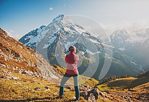 Woman hiker standing on the top of mountain. Back pose