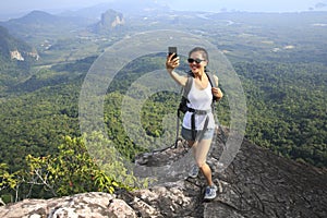 Woman hiker taking photo with cellphone