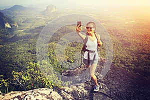 Woman hiker taking photo with cellphone