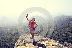 Woman hiker taking photo with cellphone