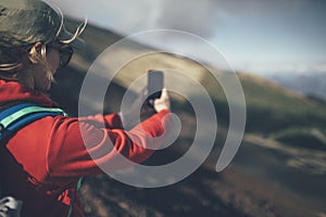 Woman hiker taking photo with smart phone