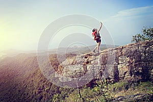 Woman hiker taking photo with smart phone at mountain peak