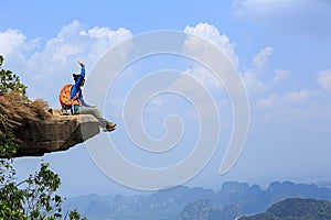 woman hiker thinking on mountain peak cliff
