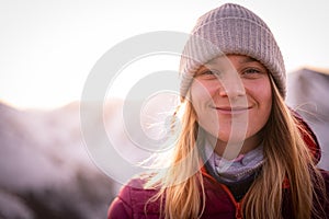 Woman hiker on a top of a mountains. First sun lights rise. Hiker relaxing in the mountain and enjoying sun. Backpack freedom conc