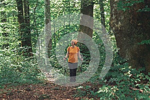 Woman hiker trekking and walking in forest