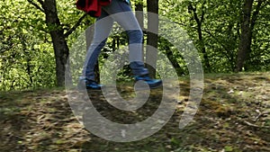 Woman hiker walking on forest edge with a backpack