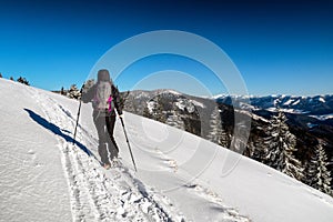 Woman hiker walking on snow in winter country