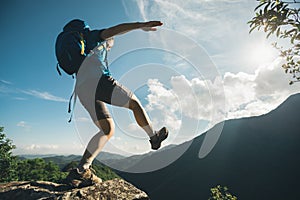 Woman hiker walking to the cliff edge photo