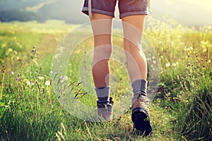Woman hiker walking on trail in grassland