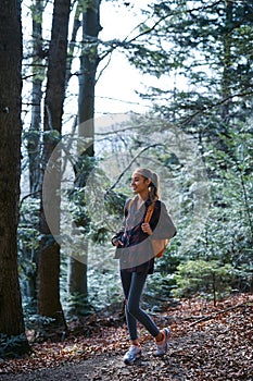 Woman hiker walking on the trail in the woods.