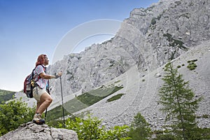 Woman hiker on the way to mountain peak, on sunny day, against clear blue sky, space for text