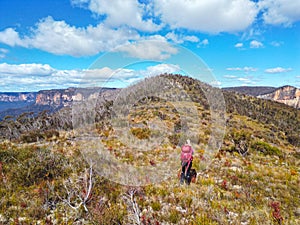 Woman hiking across an exposed hill high in the upper Blue Mountains