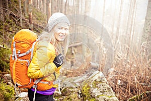 Woman hiking in autumn forest trail