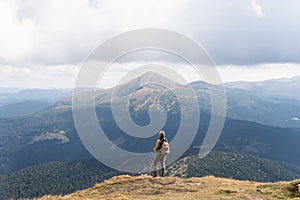 Woman hiking with backpack and trekking poles. Nature tourism in Ukrainian Carpathian mountains