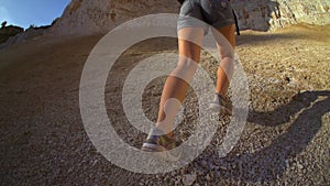 Woman hiking and climbing . Strong determined tourist woman is climbing the rock in sunny mountains. Slow motion filmed