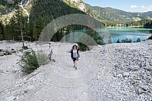 Woman hiking Croda del Becco trail over Lago di Braies. Trentino, Dolomiti Italy