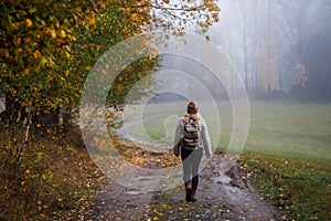 Woman hiking on footpath in autumn forest