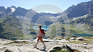 Woman hiking on footpath in idyllic mountain landscape with blue lake, high mountain peak and glacier. Summer adventures on the Al