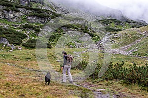 Woman hiking with her dog in the High Tauern National Park
