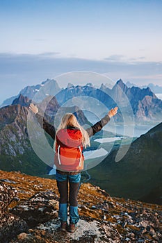 Woman hiking in Norway active travel lifestyle girl traveler success raised hands on mountain top in Lofoten islands