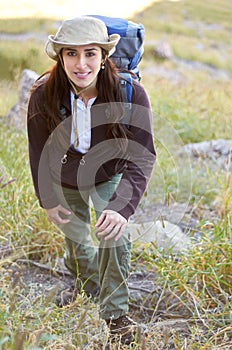 Woman, hiking portrait and smile on mountain to start adventure, journey or fitness with backpack in nature. Girl hiker