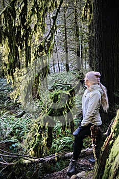 Woman hiking in rain forest in North Vancouver in spring.