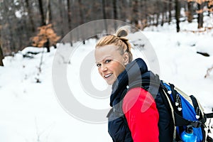 Woman hiking on snow in winter forest