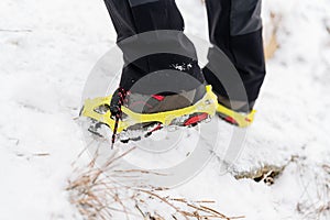 Woman hiking in the snowy mountains. Crampons on shoes.