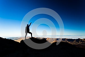 Woman hiking success silhouette on mountain top