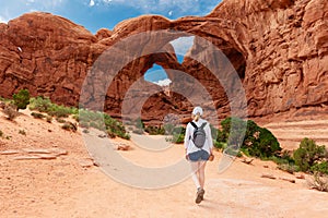 Woman Hiking to Double Arch in Utah National Park