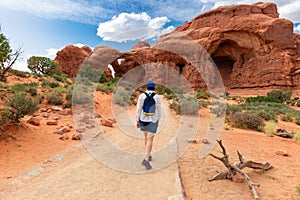 Woman Hiking to Double Arch in Utah National Park