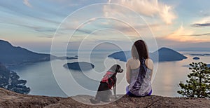 Woman hiking on top of a mountain with a dog