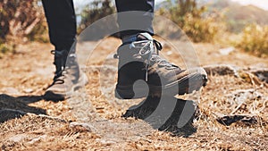 A woman hiking with trekking boots on the top of mountain