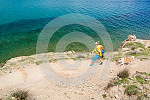 Woman hiking walking with dog on seaside trail