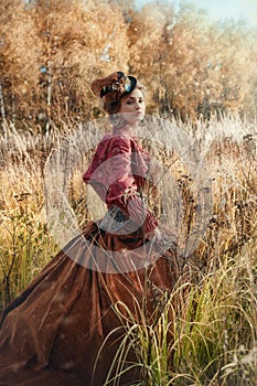 Woman in a historical costume in the autumn forest.