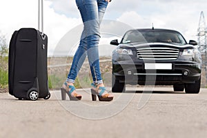 woman hitchhiking with her luggage