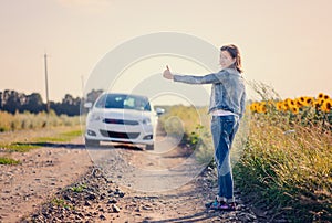 Woman hitchhiking on a rural road