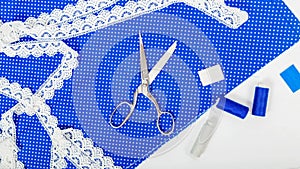 Woman hobby. Set for tailor shop with scissors, sewing tools, blue fabric on white background top view copy space