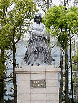 Woman hold baby in her arm (image of 50 anniversary monument )