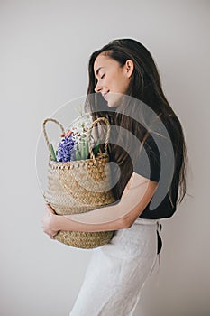 Woman hold basket of flowers on white background.