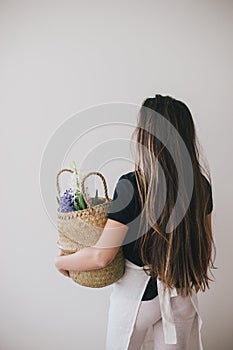 Woman hold basket of flowers on white background.