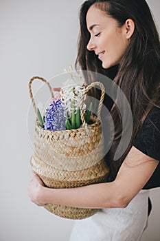 Woman hold basket of flowers on white background.