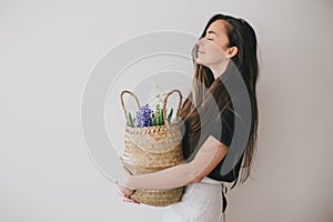 Woman hold basket of flowers on white background.